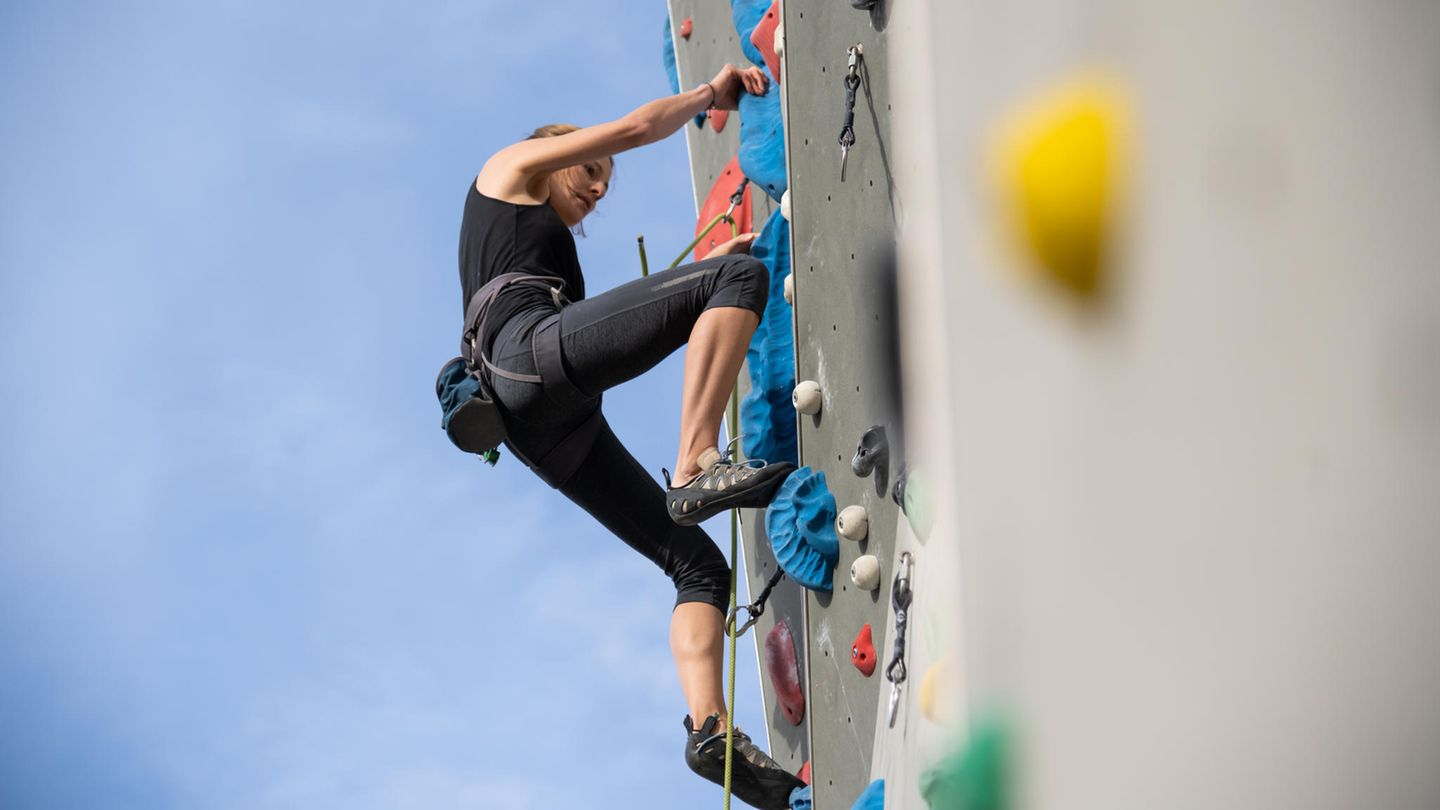 Eine Frau beim Outdoor-Klettern an der Kletterwand 