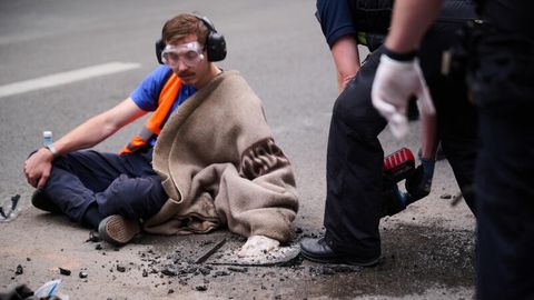 Ein Aktivist der Letzten Generation hat sich auf einer Straße festgeklebt