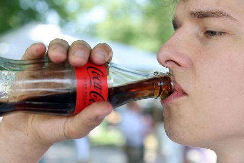 Junger Mann trinkt Cola zero