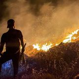 Ein Mann beobachtet während einer Hitzewelle loderndes Feuer auf einem Hügel in der südlibanesischen Stadt Ibl al-Saqi.