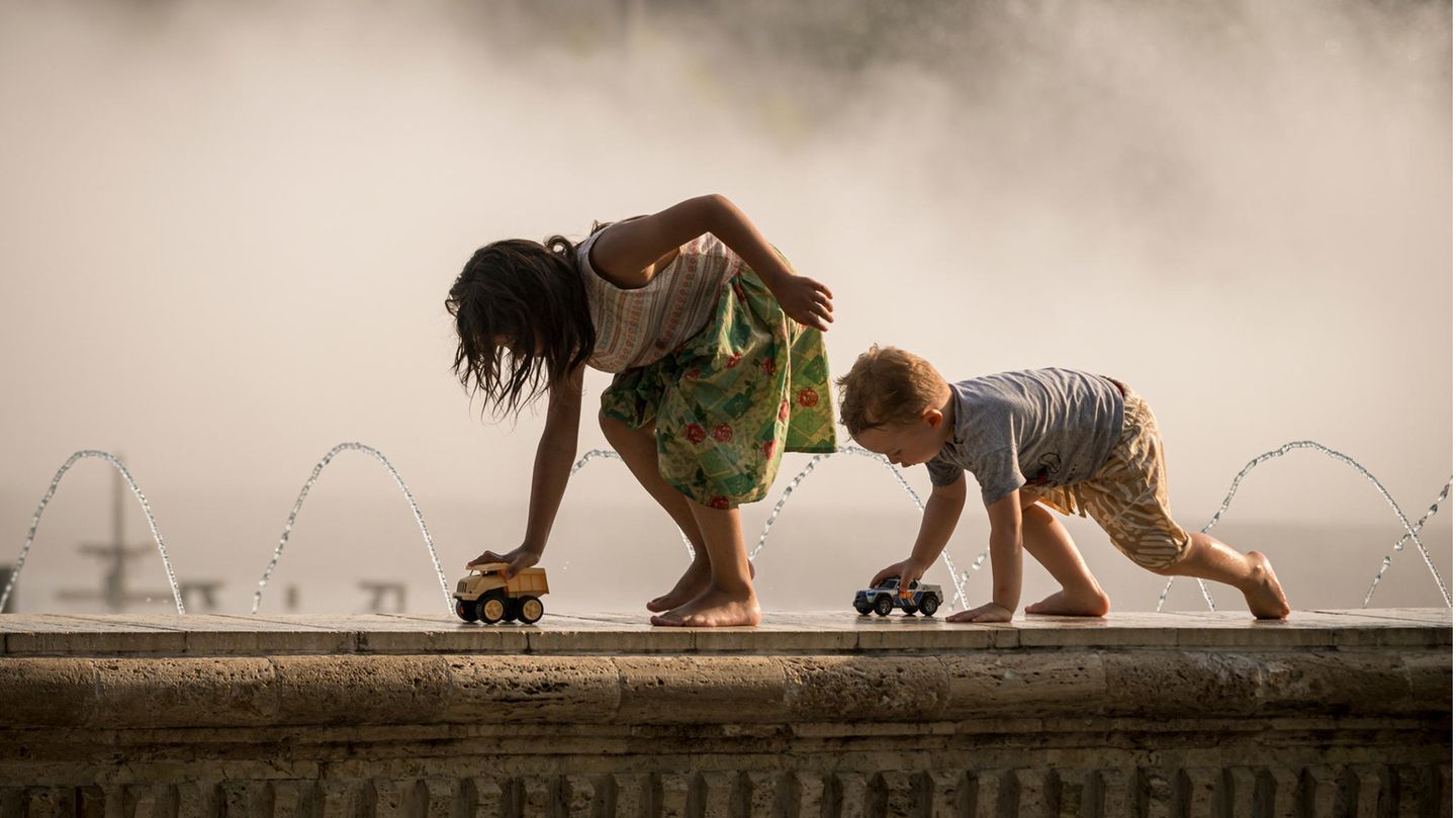 Kinder spielen und erfrischen sich in einem öffentlichen Brunnen. Die Wetterdienste haben für die laufende Woche eine Hitzewarnung für Südrumänien herausgegeben, da die Temperaturen im Schatten 40 Grad Celsius übersteigen sollen.