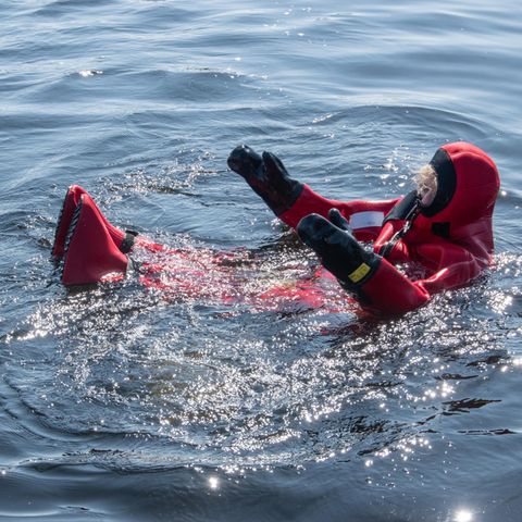 Eingepackt in einen Trockenanzug treibt eine Teilnehmerin der Masterclass in Fluss.