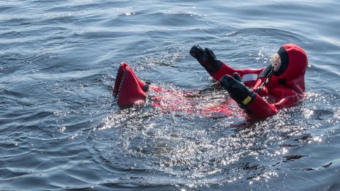 Eingepackt in einen Trockenanzug treibt eine Teilnehmerin der Masterclass in Fluss.
