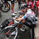 Tour-Favorit Tadej Pogacar vom Team UAE macht es sich auf dem Randstein der Brücke bequem. Er nimmt die Unterbrechung sichtlich gelassen, wie es seine Art ist.