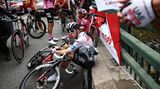 Tour-Favorit Tadej Pogacar vom Team UAE macht es sich auf dem Randstein der Brücke bequem. Er nimmt die Unterbrechung sichtlich gelassen, wie es seine Art ist.