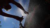 Im bayerischen Kaufbeuren kühlt sich eine Frau in einem Garten mit Wasser aus einem Gartenschlauch ab