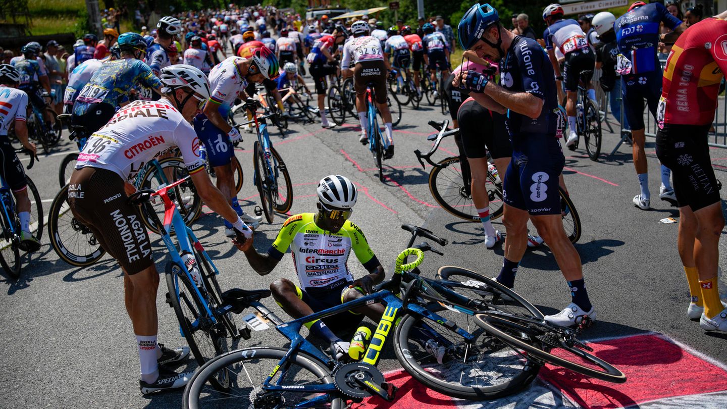 Chaos bei der Tour de France: Nachdem ein Fan für einen Massensturz gesorgt hat, hilft Olivier Naesen (links) Biniam Girmay wieder auf die Beine