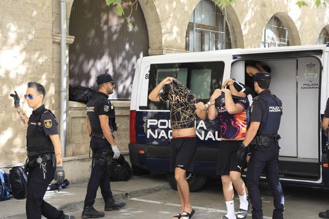 Mutmaßliche Vergewaltiger, die aus dem Polizeiwagen aussteigen und zum Haftrichter geführt werden.