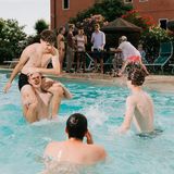 Vier junge Männer spielen im Wasser Wrestling