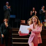 Ein junges Mädchen mit strahlendem Gesicht und Umschlag in der Hand