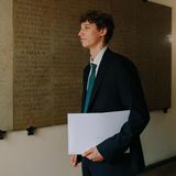 Junger Mann mit Umschlag unter dem Arm