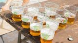 Ein Tisch auf dem Plastikbecher mit Bier gefüllt stehen