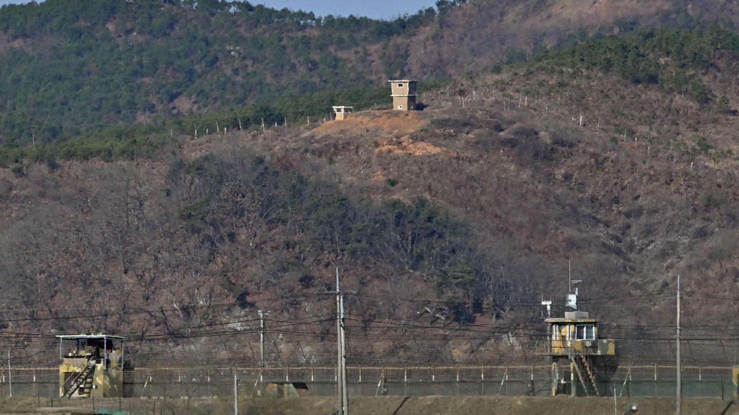 Ein nordkoreanischer Wachposten (oben) ist über einem südkoreanischen Militärzaun zu sehen (unten)