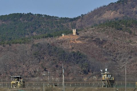 Ein nordkoreanischer Wachposten (oben) ist über einem südkoreanischen Militärzaun zu sehen (unten)