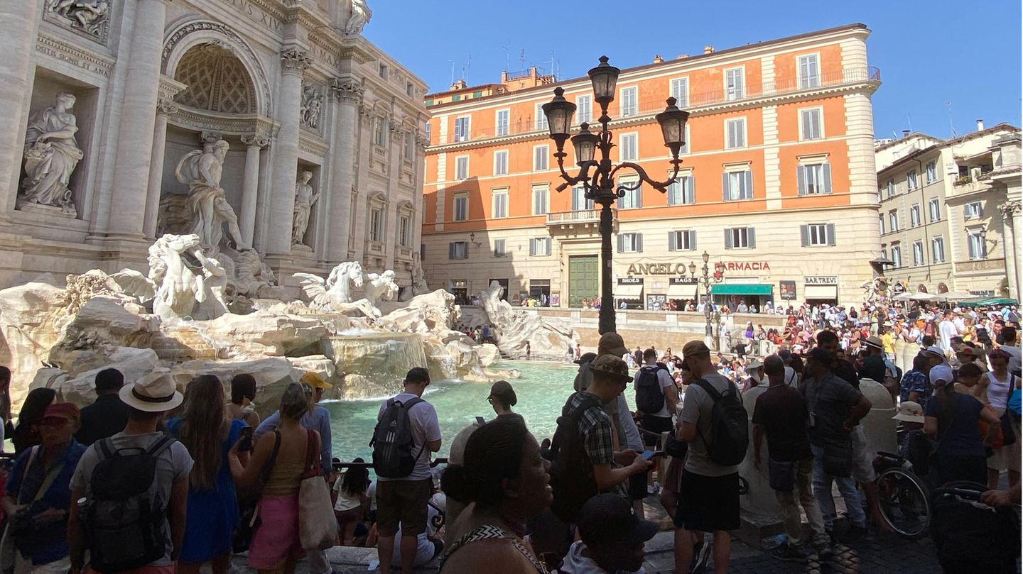 In Rom stehen Touristen am Trevi-Brunnen angesichts von mehr als 40 Grad im Schatten In Rom stehen Touristen am Trevi-Brunnen angesichts von mehr als 40 Grad im Schatten