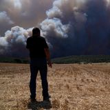 Ein Mann steht auf einem Feld in Inoi und betrachtet den Rauch eines Feuers in der Nähe von Athen. Den dritten Tag in Folge kämpfen Feuerwehrleute in Griechenland gegen drei große Feuerfronten an