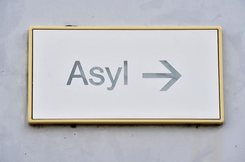 Ein Schild mit der Aufschrift "Asyl" hängt in einer Landeserstaufnahme für Asylbewerber (LEA) an einer Wand