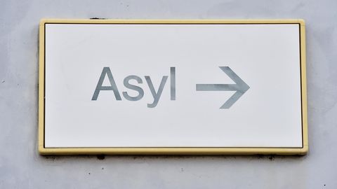 Ein Schild mit der Aufschrift "Asyl" hängt in einer Landeserstaufnahme für Asylbewerber (LEA) an einer Wand