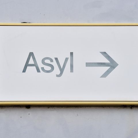 Ein Schild mit der Aufschrift "Asyl" hängt in einer Landeserstaufnahme für Asylbewerber (LEA) an einer Wand