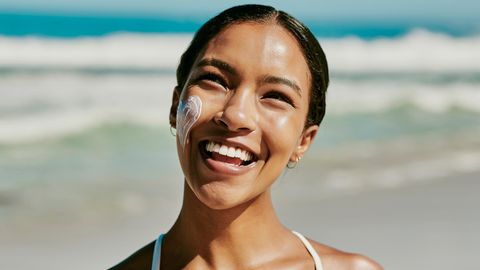 Nachhaltige Sonnencreme: Eine Frau steht am Strand und lacht