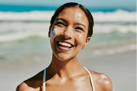 Nachhaltige Sonnencreme: Eine Frau steht am Strand und lacht
