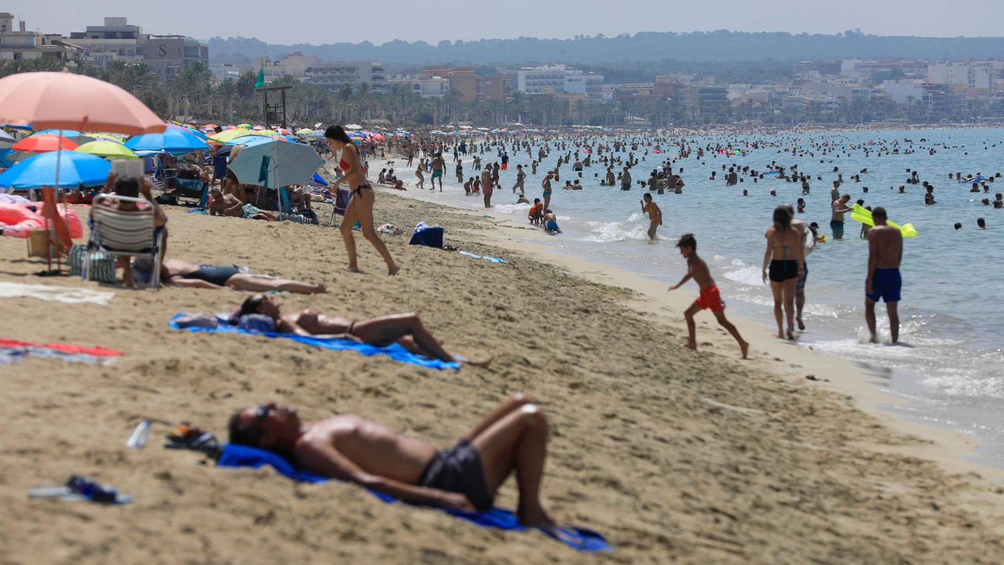 Klimawandel: Menschen schwimmen und sonnen sich bei heißen Temperaturen am Strand von Palma de Mallorca Klimawandel: Menschen schwimmen und sonnen sich bei heißen Temperaturen am Strand von Palma de Mallorca