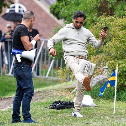 Ein Demonstrant tritt nach einem Koran