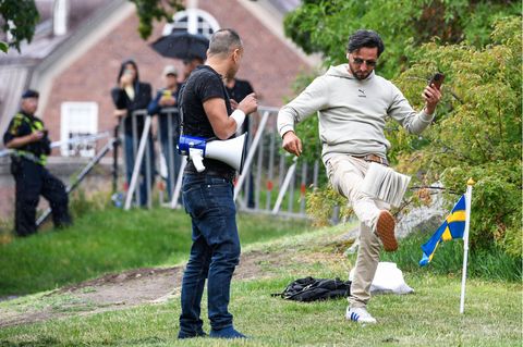 Ein Demonstrant tritt nach einem Koran