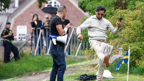Ein Demonstrant tritt nach einem Koran