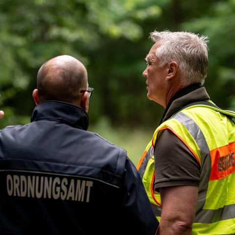 Der Gemeindejäger (r.) und ein Mitarbeiter Ordnungsamt durchsuchen im Bereich der südlichen Landesgrenze von Berlin den Wald