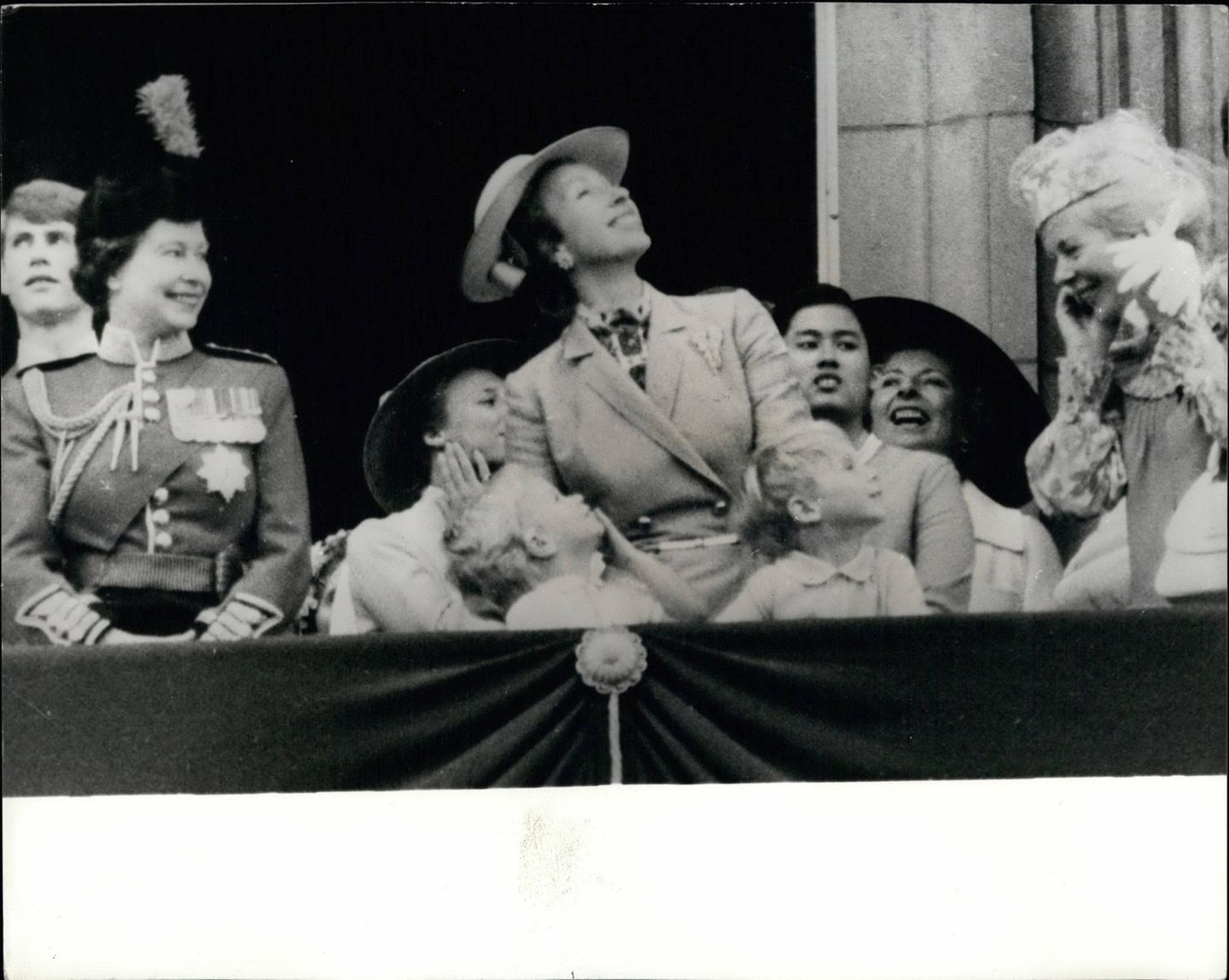 1980 steht Prinzessin Anne neben ihrer Mutter und einem blutjungen Prinz Edward (ganz links) auf dem Balkon des Buckingham Palastes und beobachtet die Flugzeug-Parade anlässlich von "Trooping the Colour". An diesem Tag trägt sie einen senfgelben Mantel mit goldenem Gürtel