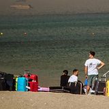Touristen warten am Strand von Rhodos darauf, vor den Waldbränden evakuiert zu werden