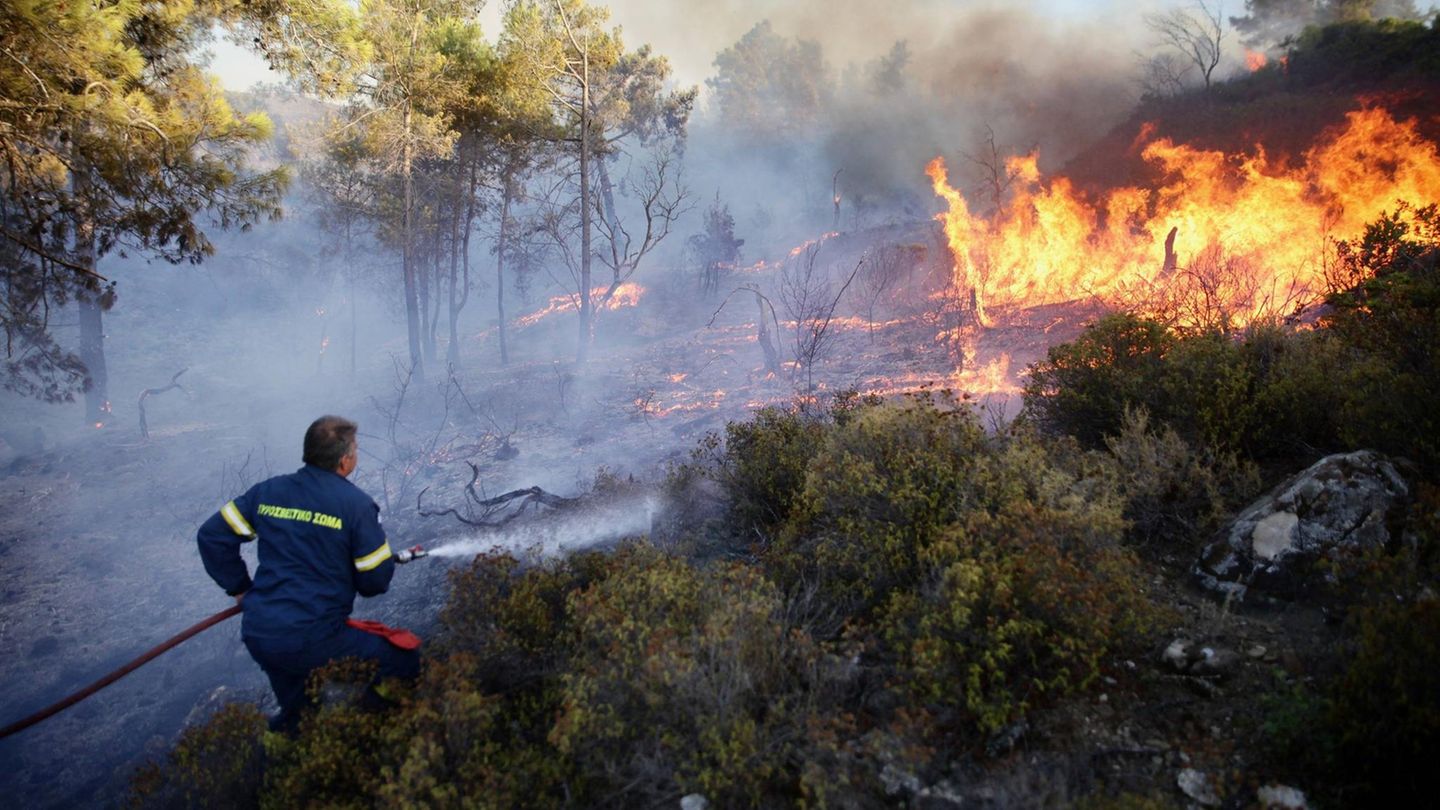 Griechische Feuerwehrleute müssen die Flammenwände an gleich mehreren Fronten bekämofen