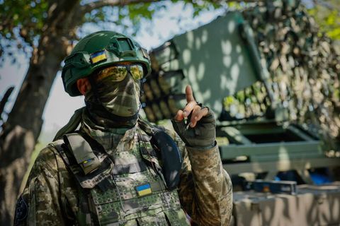 Ein Soldat in der Ukraine gestikuliert, während er einen Mehrfachraketenwerfer vorbereitet