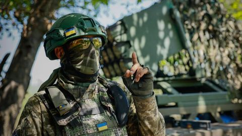 Ein Soldat in der Ukraine gestikuliert, während er einen Mehrfachraketenwerfer vorbereitet