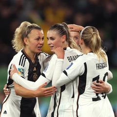Bei der Fußball-WM bilden vier junge Frauen im DFB-Dresse ein Tor gegen Marokko