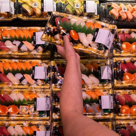Eine Kundin hält Sushi mit aus Japan importierten Meeresprodukten in der Hand