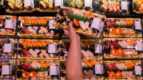 Eine Kundin hält Sushi mit aus Japan importierten Meeresprodukten in der Hand