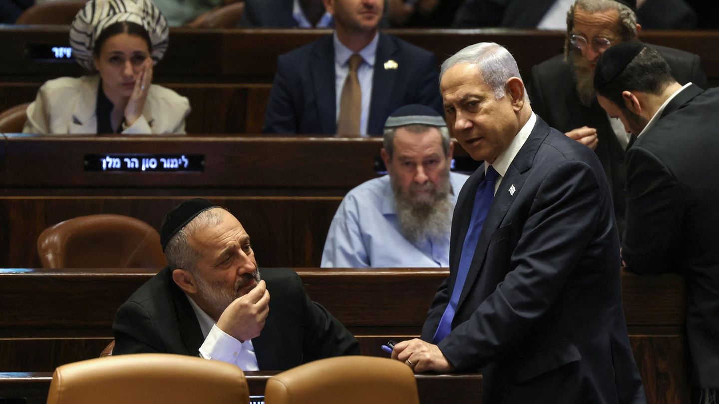 Israels Premierminister Benjamin Netanjahu (R) spricht mit Aryeh Deri (L), dem Vorsitzenden der ultraorthodoxen Partei Schas