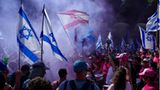 Menschen demonstrieren mit Fahnen und Pyrotechnik gegen die Justizreform