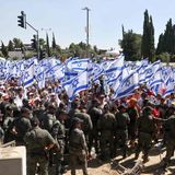 Israelische Sicherheitskräfte stehen Wache, während Demonstranten die Nationalflagge