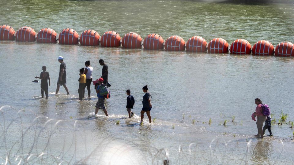 Migranten gehen an der Grenze zu Mexiko am Rio Grande entlang