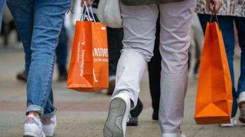 Menschen mit vollen Einkaufstaschen gehen an den Geschäften in der Tauentzienstraße in Berlin vorbei