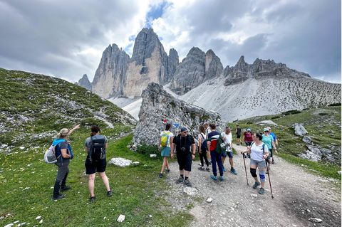 Wanderer in Südtirol passieren eine Gedenktafel für einen verunglückten Bergsteiger am Drei Zinnen Rundwanderweg
