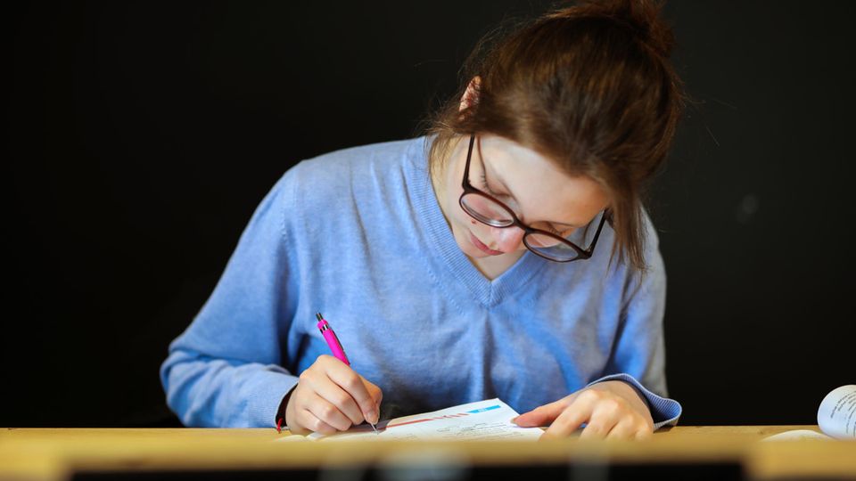 Schulbuch.Studie Bremen: Ein Mädchen liest in einem Buch