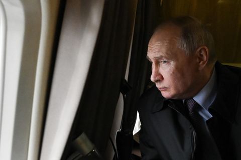Wladimir Putin schaut aus dem Fenster eines Flugzeugs