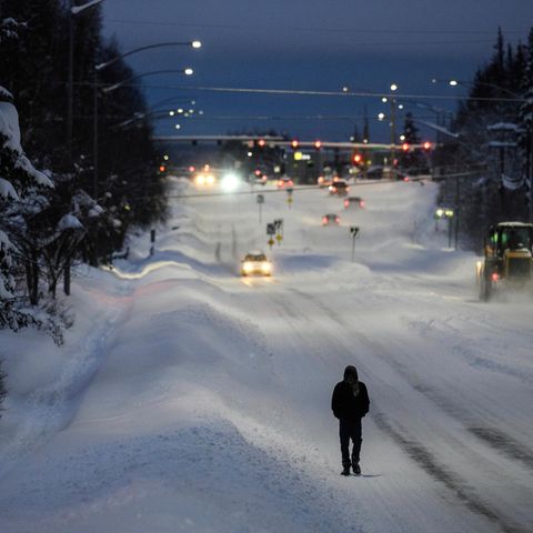 Mann läuft beschneite Straße in Anchorage, Alaska entlang