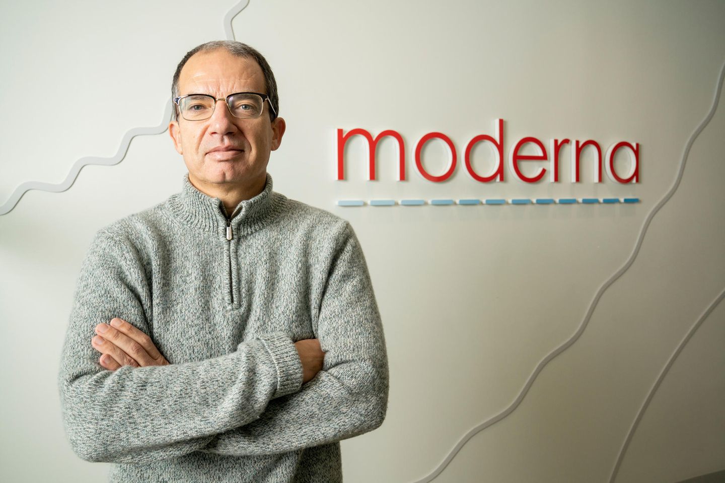 Moderna-Chef Stéphane Bancel Stéphane Bancel, Chef der US-amerikanischen Pharmafirma Moderna, steht mit verschränkten Armen vor dem Logo des Unternehmens.