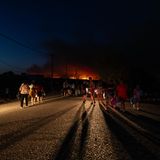 Rhodos: Menschen auf der Straße,  im Hintergrund sind Flammen