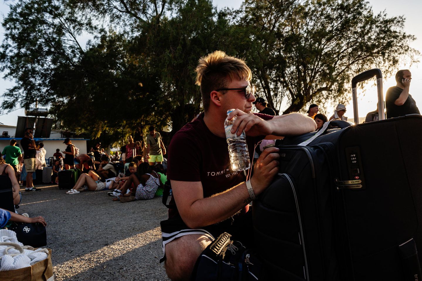 Rhodos: Viele Menschen sitzen mit ihrem Gepäck im Freien